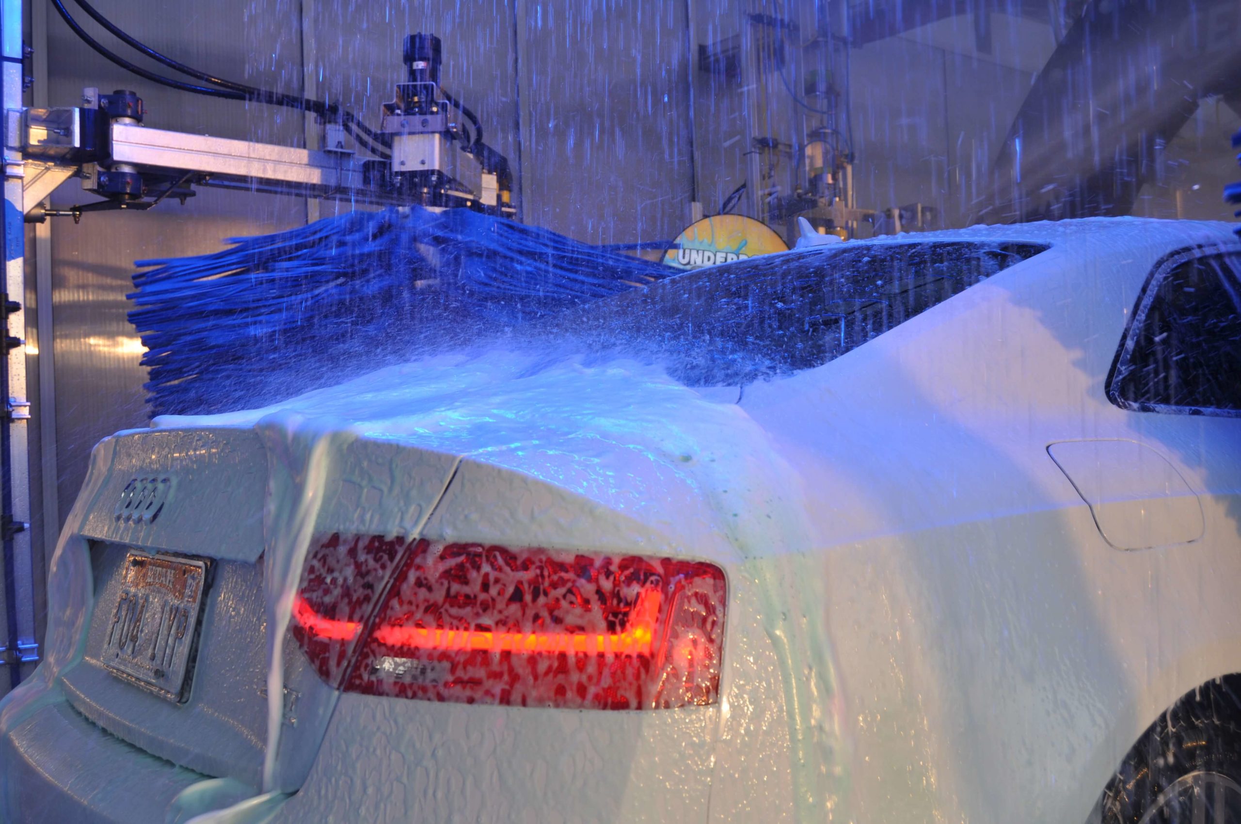 Car inside of tunnel getting washed